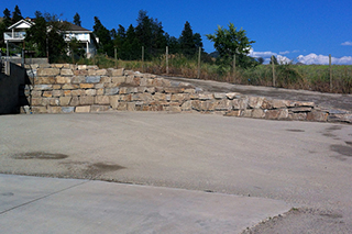 Natural stone wall retaining driveway